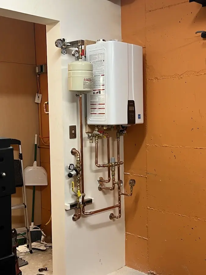 Plumbing technician inspecting water heater connections in Duryea